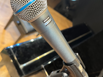 マイクスタンドに設置されたマイク。Shureのロゴ入り。イベント、会議、プレゼンテーション用。