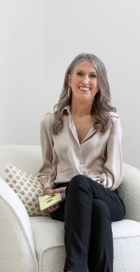 Image of Dr Maxine Therese sitting on a chair and smiling directly into the camera