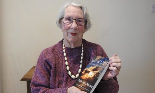 woman holding a book, next to a coffee mug