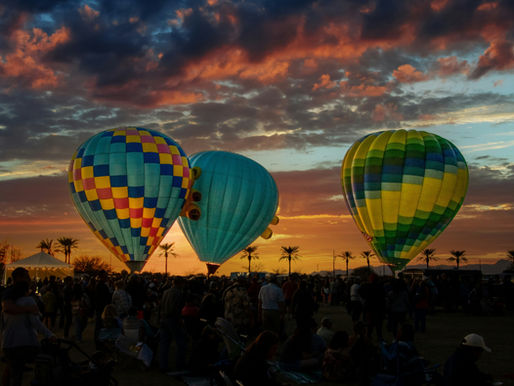 Hot air balloons gracefully float against a stunning sunset backdrop in Goodyear, Arizona.