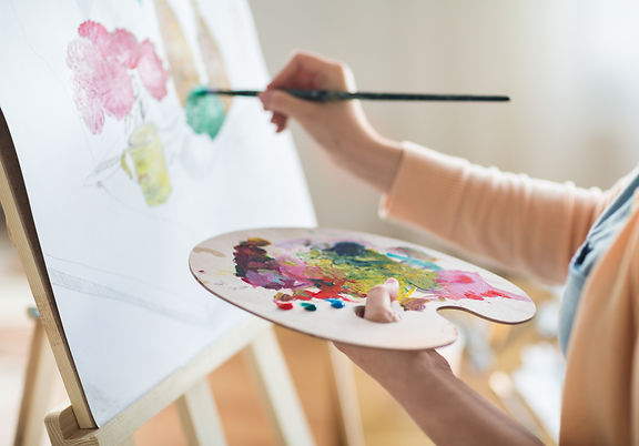 art, creativity and people concept - close up of artist with palette and brush painting st