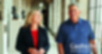 Two smiling Nebraska public officials stand together inside a sunlit government building.