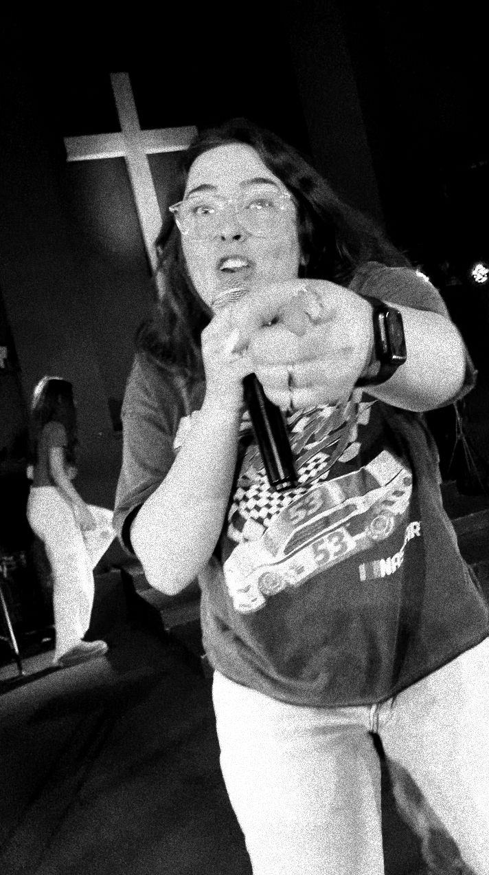 Teenager singing and pointing at the audience