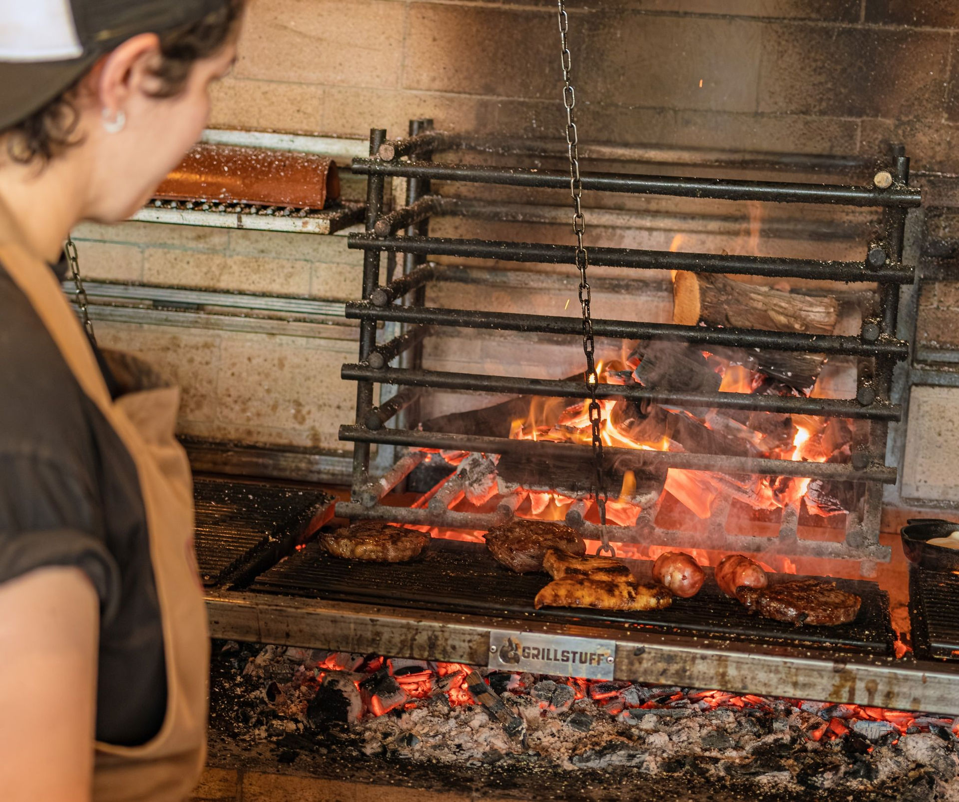 Carne sendo preparada em parrilla tradicional