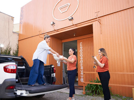 Público conferindo peças sustentáveis no Bazar Caçamba do Bem com foco em arquitetura circular