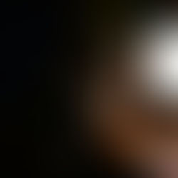 A man with his head in his hands in front of a computer screen