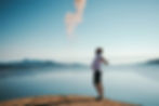 Man standing on mountain with arms in the air feeling happy