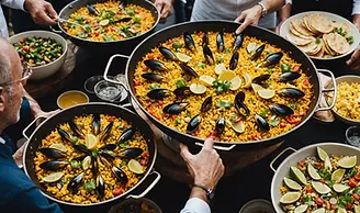 A colorful traditional Spanish paella dish being cooked in a large pan over a stove.