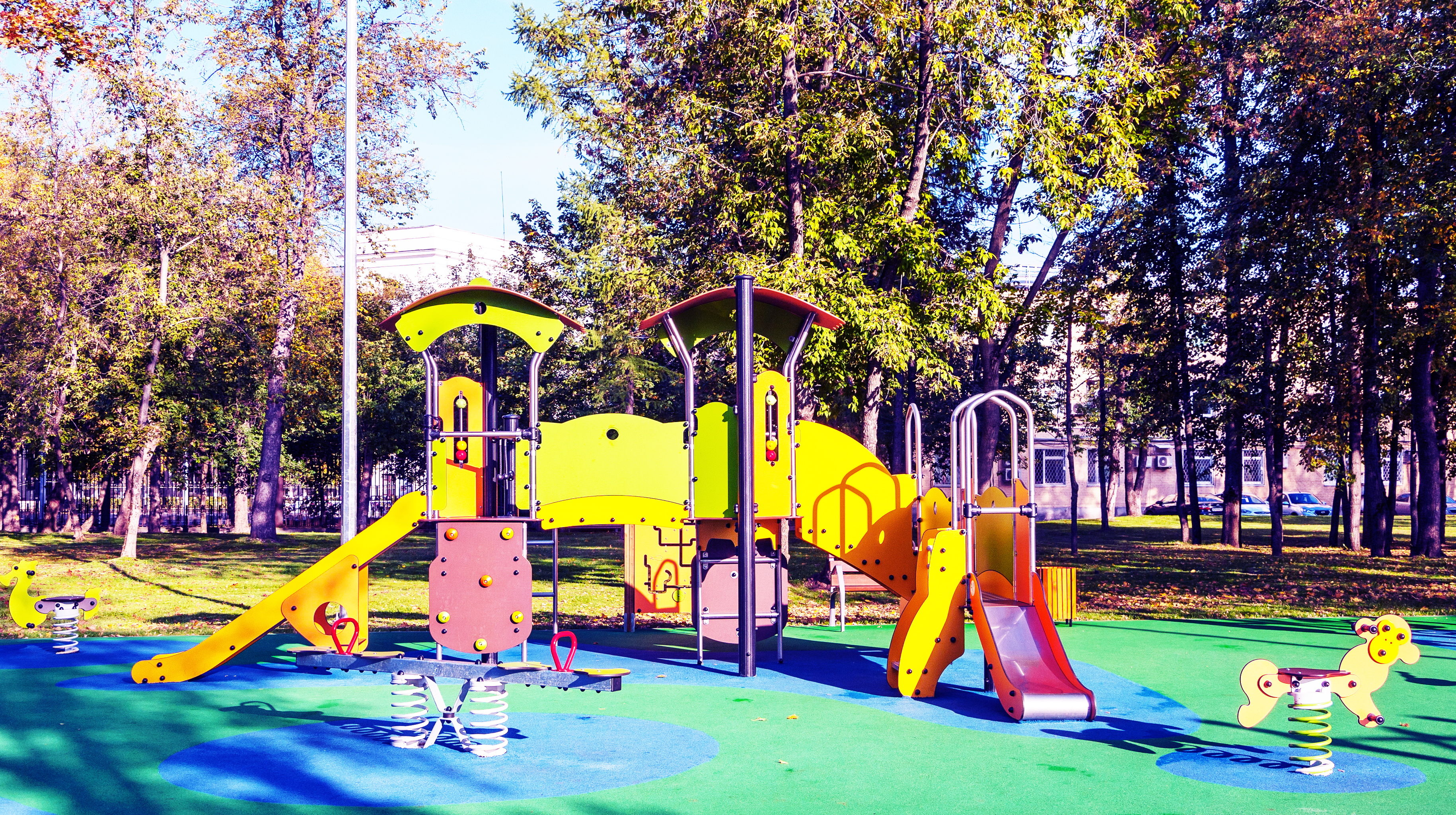Aire de jeux colorée avec sol en forme de tapis et jeux ludiques pour enfants.