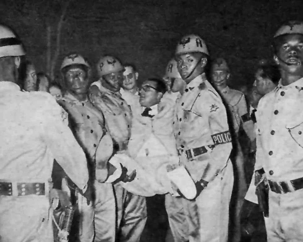 Carlos Lacerda amparado por policiais após o atentado na Rua Tonelero. Crédito da Imagem: Wikimedia Commons