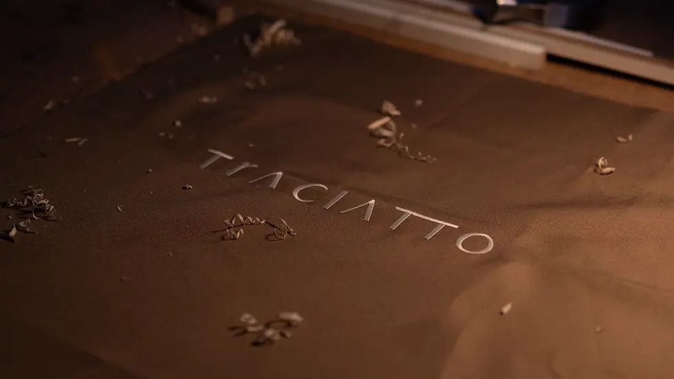 TECIDO BOARDADO COM A MARCA DA TRACIATTO MARCENARIA E MOBILIÁRIO.webp