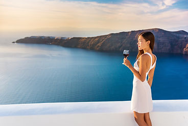a-woman-enjoying-a-glass-of-wine-looking-out-at-the-water