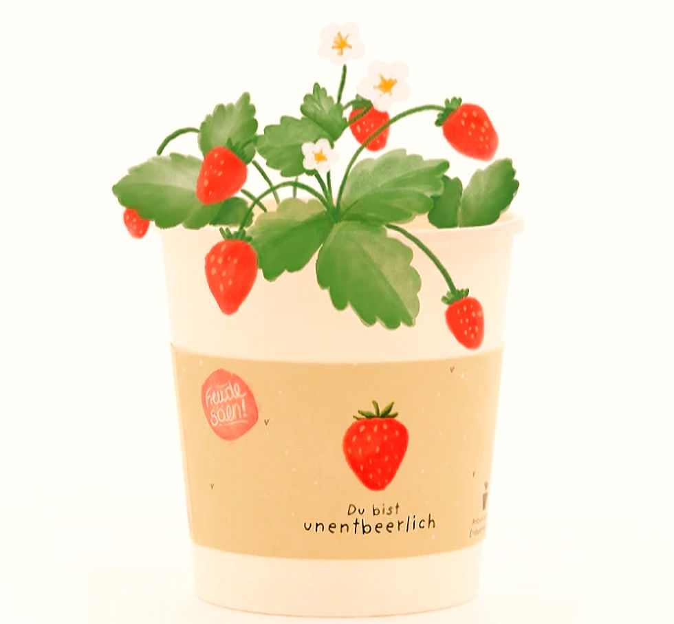 Blumentopf mit Erdbeerpflanze, rote Früchte und weiße Blüten. Etikett: "Du bist unentbeerlich", "Freude säen!" in rotem Kreis.
