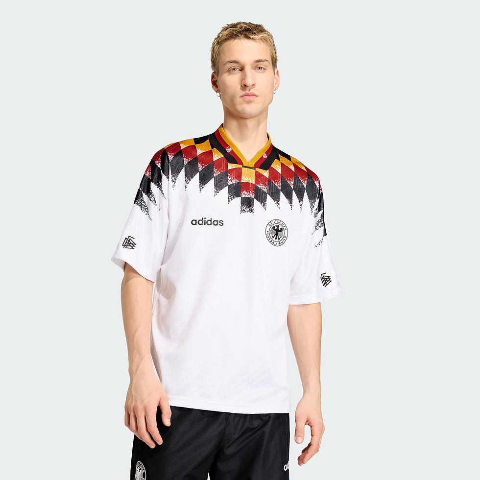 Junger Mann im weißen Deutschland-Trikot mit adidas- und DFB-Logo, vor hellem Studiohintergrund, neutraler Blick.