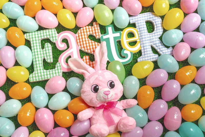 Rosa Hase liegt in bunten Ostereiern zum Thema Ostergeschenke Erwachsene Osternest befüllen Ideen