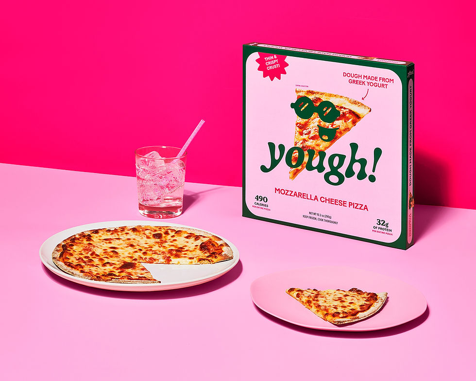 Pizza with slice missing on pink plates, box labeled "yough!" in pink setting. Glass of sparkling drink with straw nearby. Fun mood.