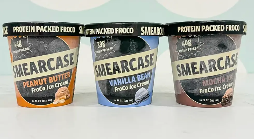 Three Smearcase FroCo ice cream tubs—peanut butter, vanilla bean, and mocha—lined up on a white surface against a pale background.