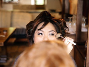 a makeup artist applying makeup to a bride