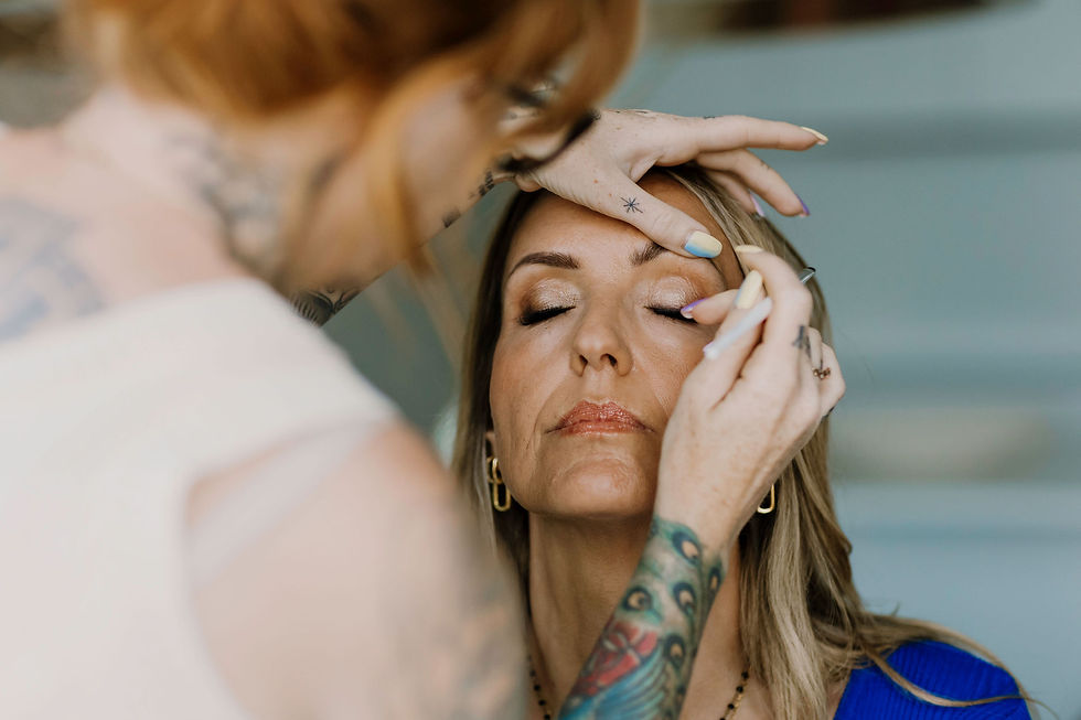 Eye-level view of a makeup artist applying makeup to a woman before a personal branding shoot