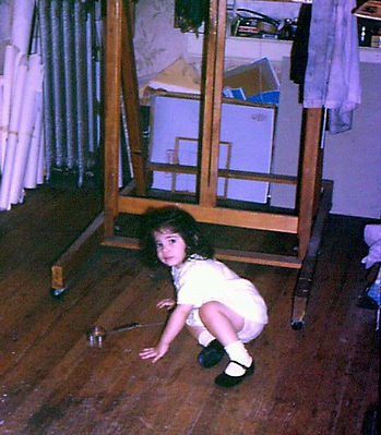Chantell Van Erbé as a toddler in her father's art studio, surrounded by canvases and easels