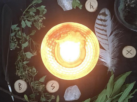 candle with feather hawthorne and runes
