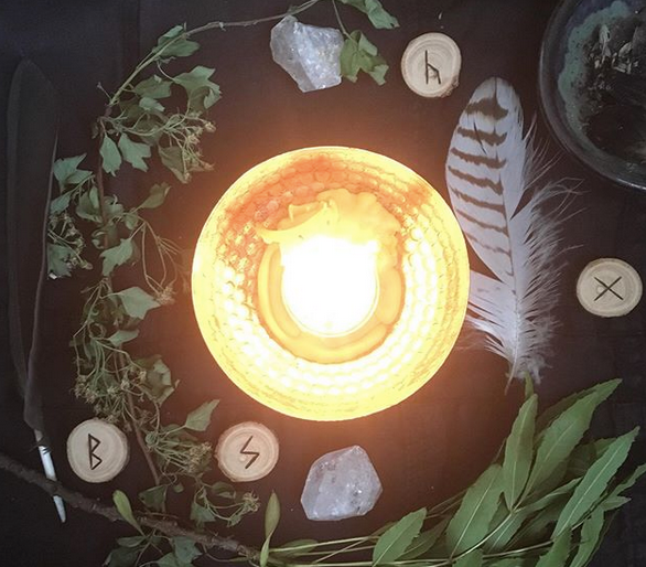 candle with feather hawthorne and runes