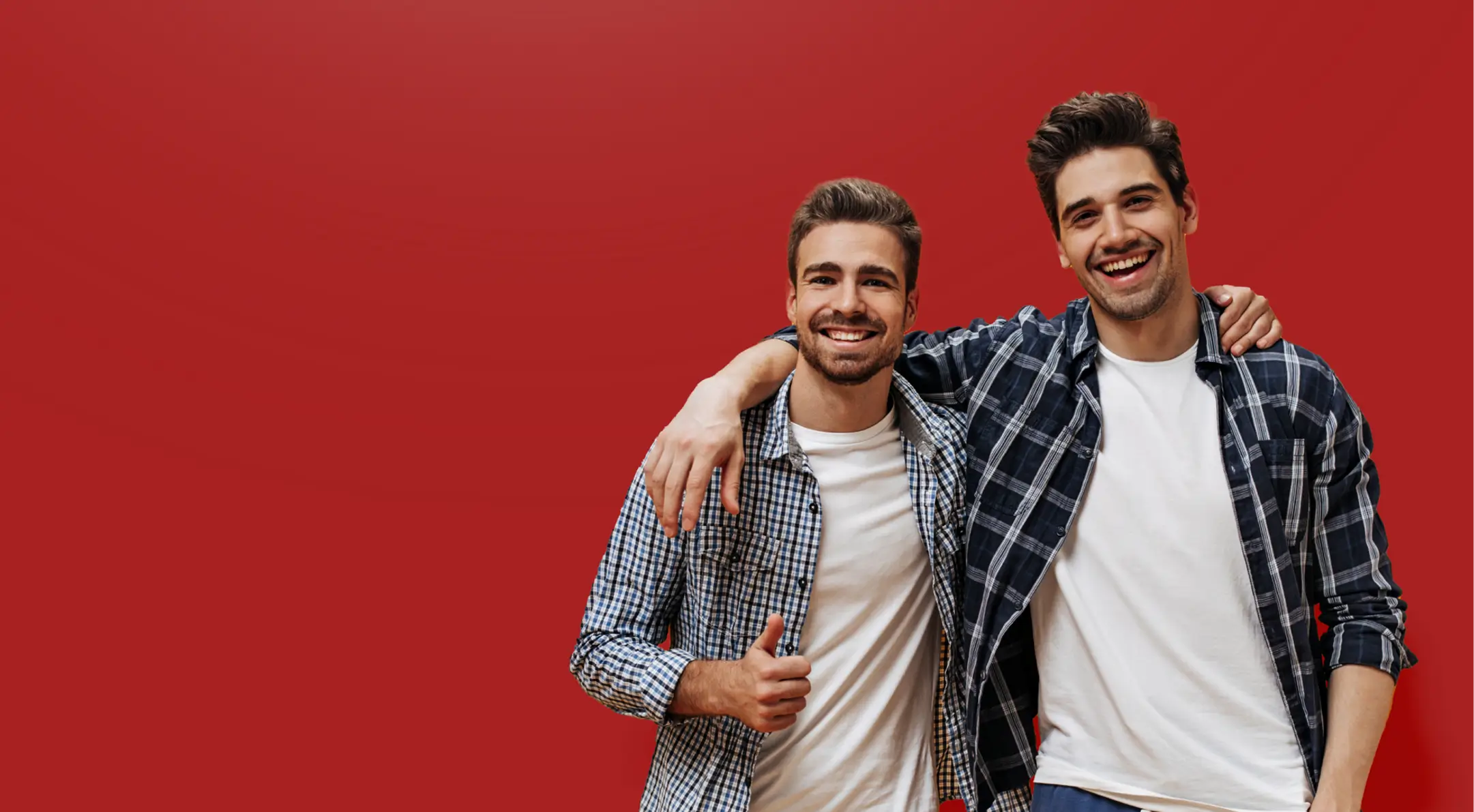 two_men_hugging_red_bg_desktop.webp