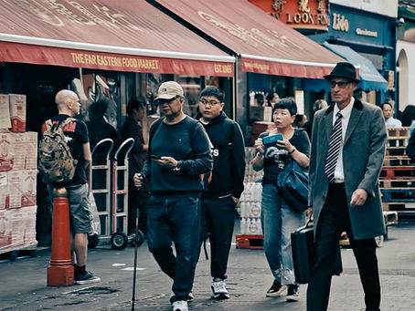 Officer Carstairs walks undetected through Chinatown during daylight, sourrounded by Chinese members of the public, unaware he is on a secret mission to deliver classified documents