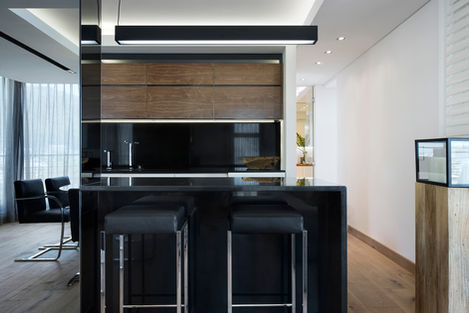 A minimalist kitchen showcasing luxurious black marble and rich timber, interior designed by Smit Collective in Bantrybay.
