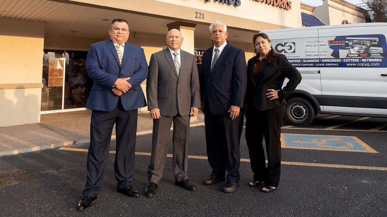 Copy Graphics sales team, sales manager, and owner standing in front of the Copy Graphics building.
