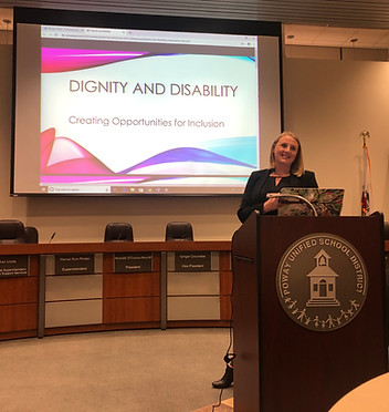 A woman stands behind a podium and smiles