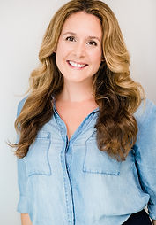 Photo of Dina, smoothed out hair, soft denim shirt, welcoming smile