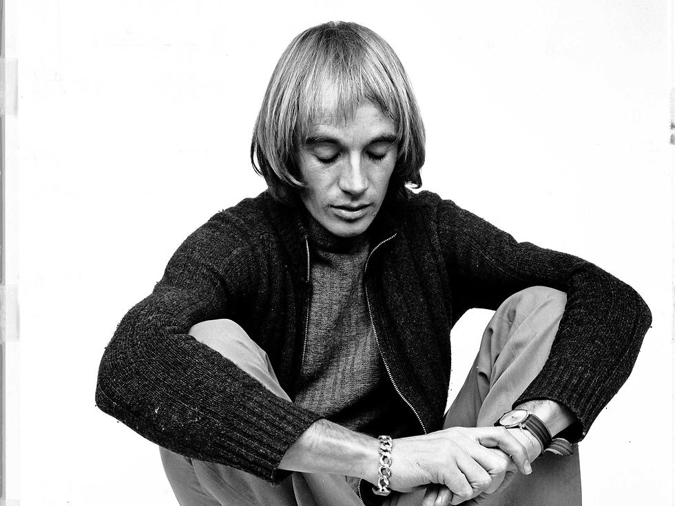 Black-and-white portrait of photographer and musician Steve Hiett seated in a studio setting.