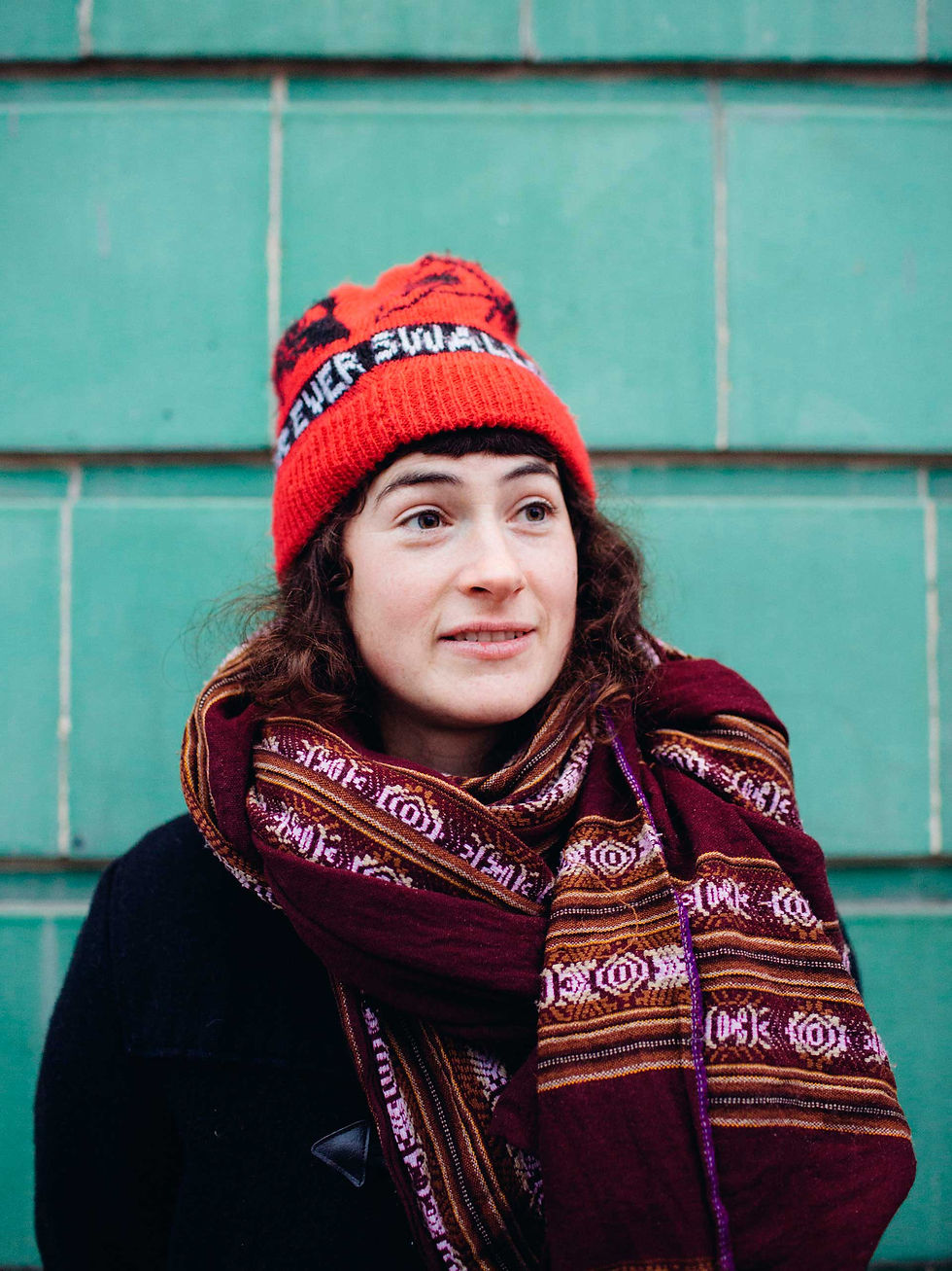 Kate Stables of This Is The Kit wearing red beanie and scarf during promotional portrait