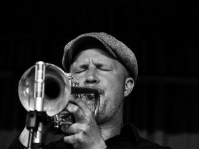 Black and white portrait of a trumpet player performing live jazz music on stage