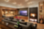 A modern basement living room with a fireplace and television