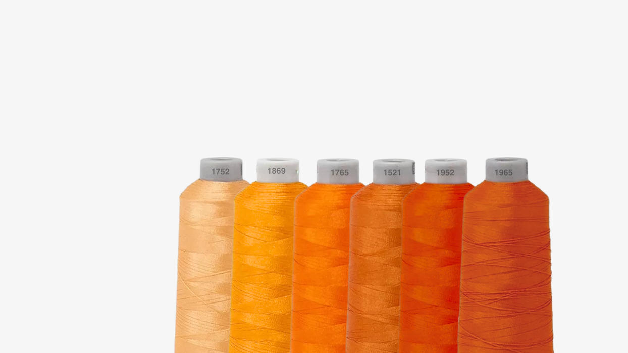 Bobine de fils de couleurs orange pour montrer au clients - Broderie Paris 