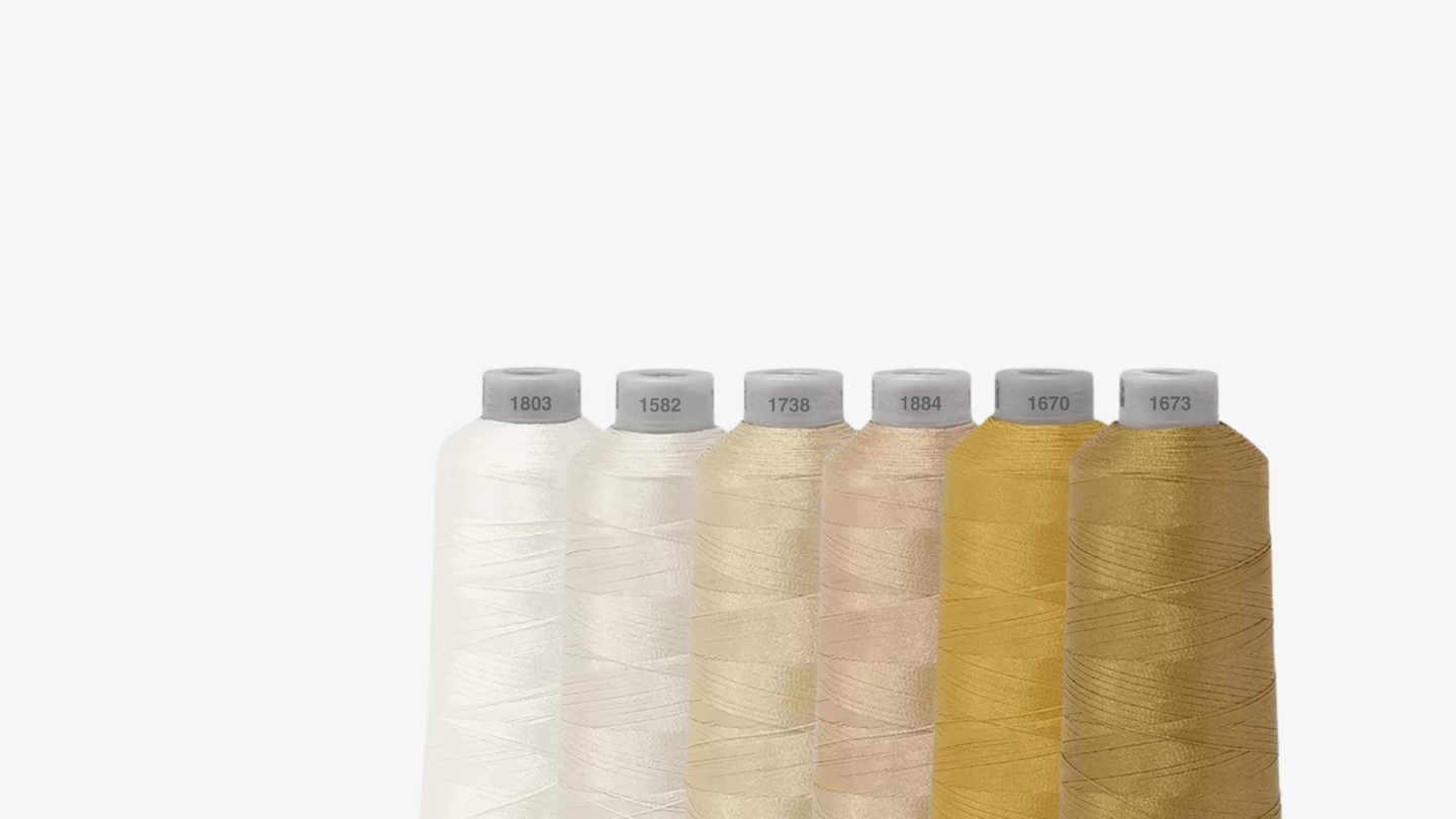 Bobine de fils de couleurs ivoire, beige & or pour montrer au clients - Broderie Paris