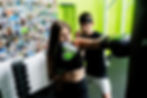 girl boxing boxing bag with boxing coach