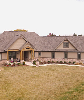 A tan house with a new asphalt shingle roof to show customers how we can repair storm damage