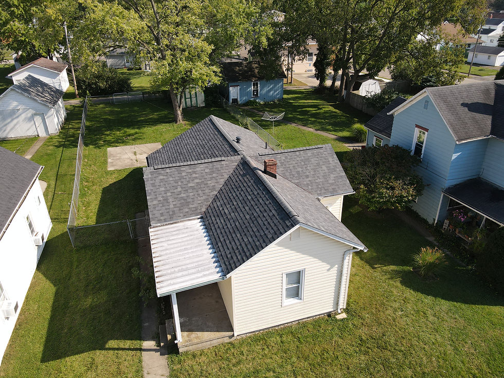 A new roof installed by a Dayton, Ohio roofing company, on a ranch-style house. The house is white and the roof is gray.