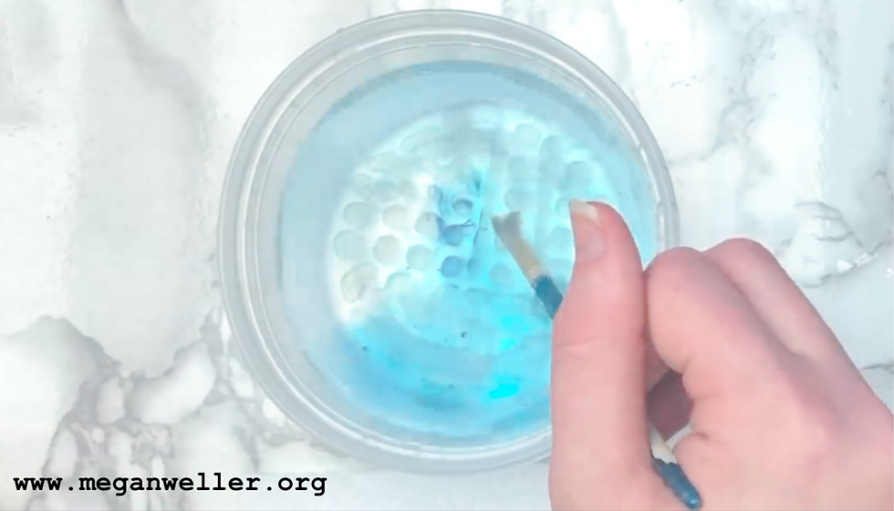 Paint water dish with blue paint swirls. How to make a paint puck paintbrush cleaner. How to clean your paintbrushes. How to clean your makeup brushes. 