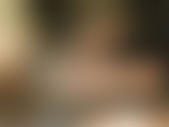 A close-up, out-of-focus photo of someone using a laptop, hands and keyboard visible, no face shown