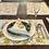 Thumbnail: Yellow green and white placemat with plates, wine glass, cutlery and napkin