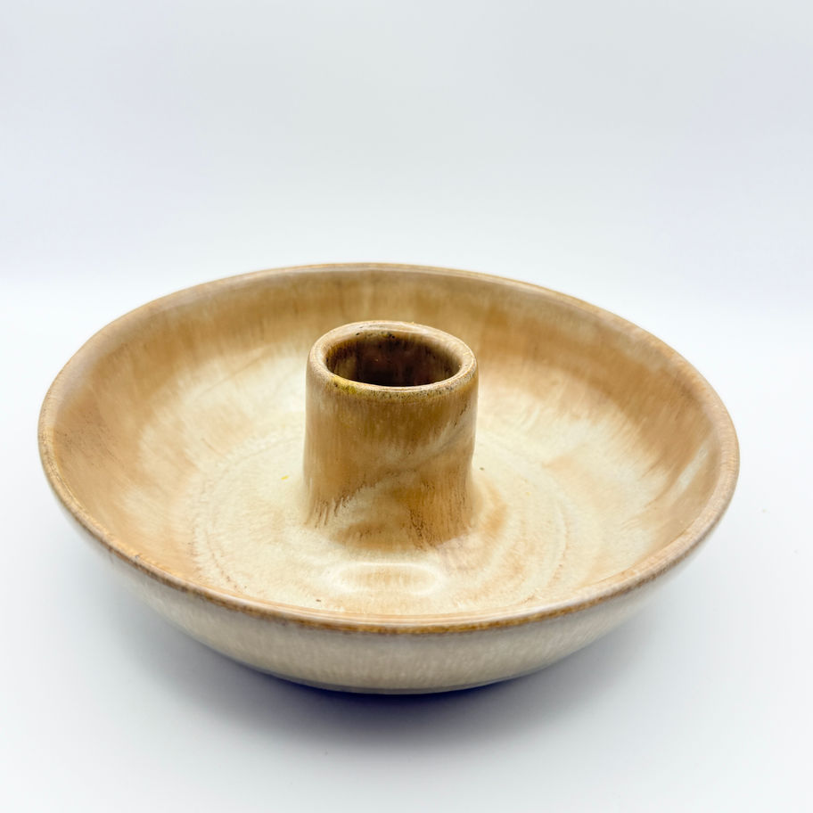 Tan glazed ceramic chamber candlestick holder with a wide shallow base on a white background.