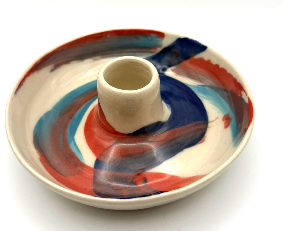 Hand-painted ceramic candle holder dish with colorful abstract blue and orange brushstrokes on a white background