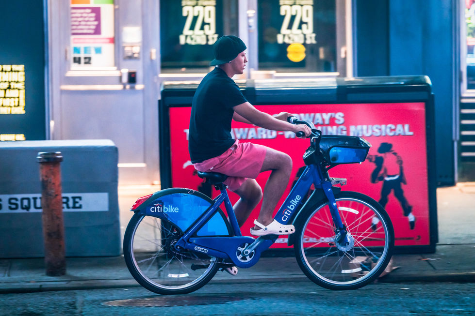 a young man riding bicycle  in times square 