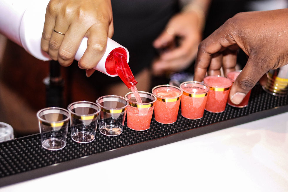 Afro Lounge bartender pouring vibrant red Afro Punch shots during nightlife service in Hollywood FL
