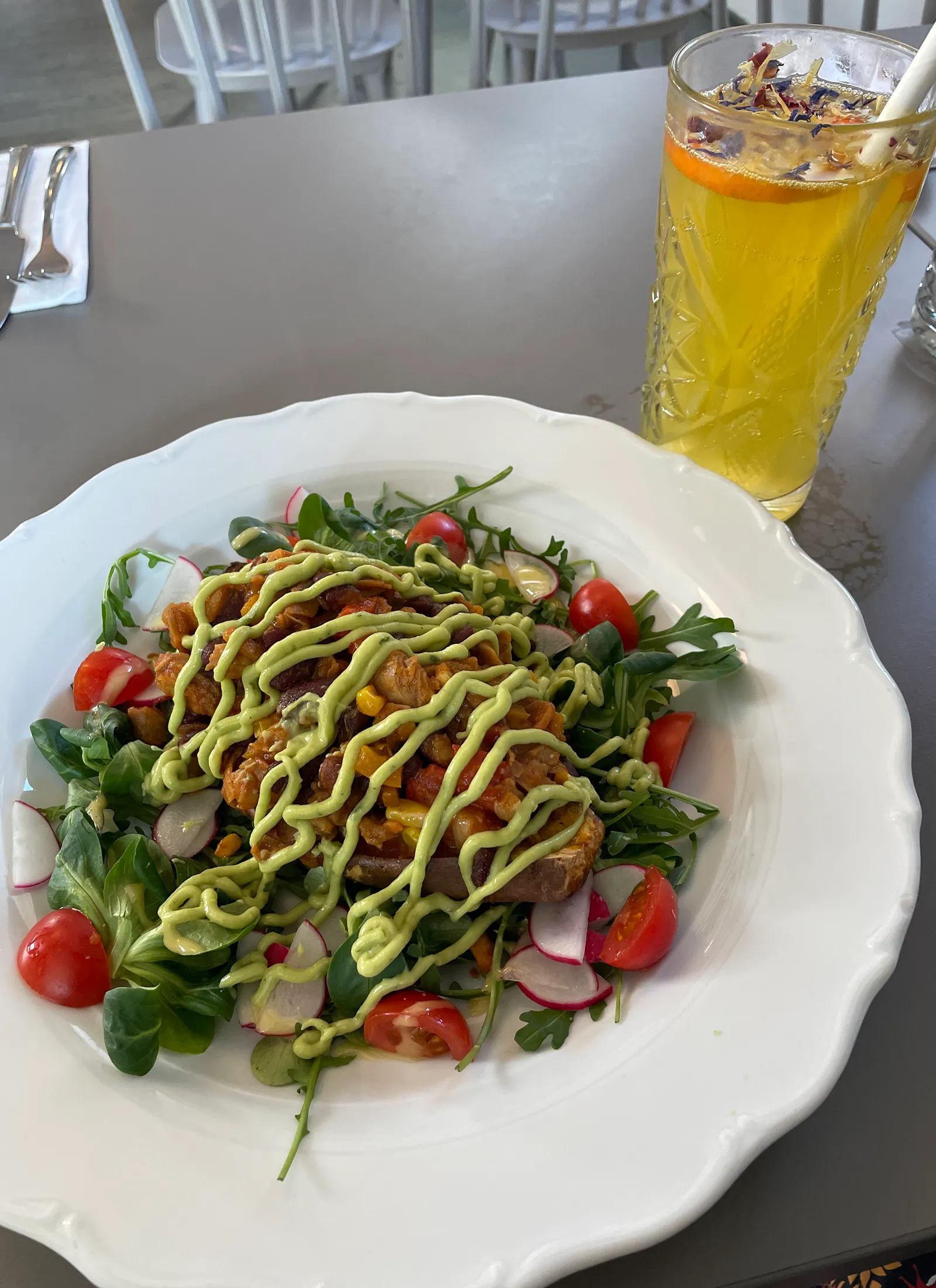 Vegan's Prague toidukohas pilt päevaroast, milleks on küpsetatud bataat, kõrval käsitöölimonaad