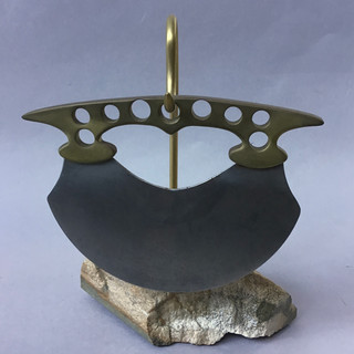 Handmade pizza cutter: Alaska style ulu shaped cutting blade with a curved, pierced brass handle. Stand of fossil whale bone. 1900